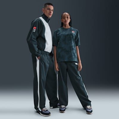 Nike x Patta Men's Track Pants in neutral colorway, showcasing tapered silhouette and contemporary track pant design